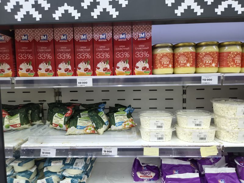 Холодильная витрина белорусских молочных продуктов: сливочный крем 33% в пакетах 1М Молочный, топлёное масло гхи Kernova в банках, моцарелла Bonfesto, творог в контейнерах с весовыми этикетками