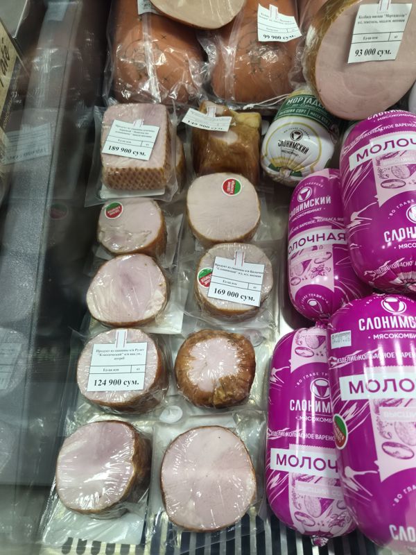 Холодильная витрина с копчёно-варёными изделиями из свинины в вакууме (лопатка, балычок, рулет, филей) и колбасами Слонимского мясокомбината: Мортаделла, «Молочная»