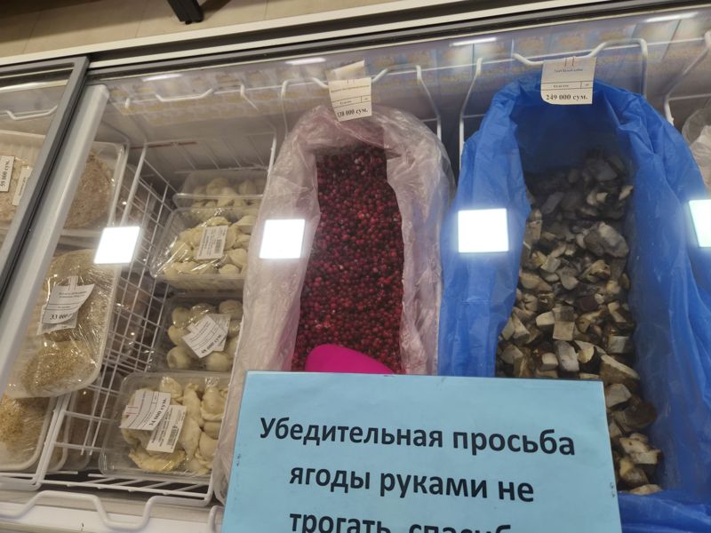 Морозильный ларь: замороженная брусника и белые грибы кубиком на развес, пельмени, вареники и котлеты в лотках; табличка «Убедительная просьба ягоды руками не трогать»
