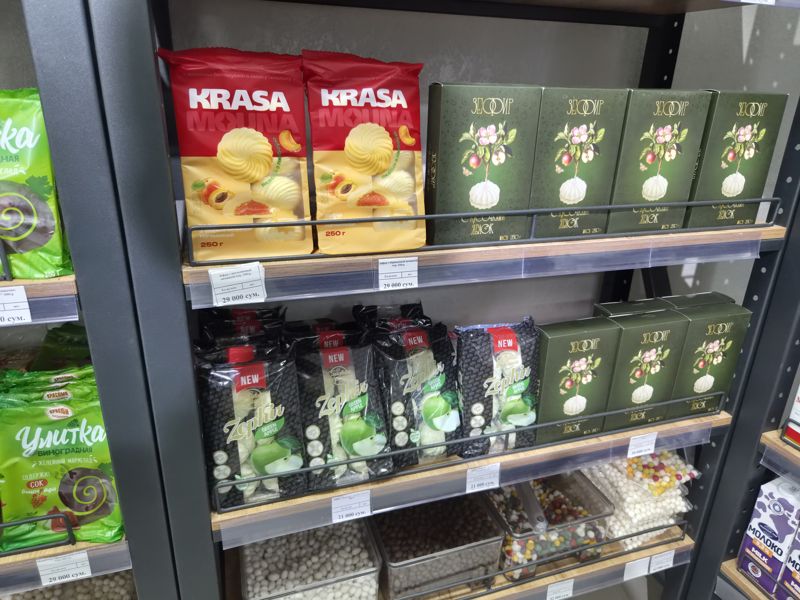 Полки с зефиром: пачки Krasa Mouna с абрикосовой начинкой 250 г, зелёные коробки «Зефир с кусочками яблок» 250 г, чёрные пачки Zephir Green Apple, внизу весовое драже
