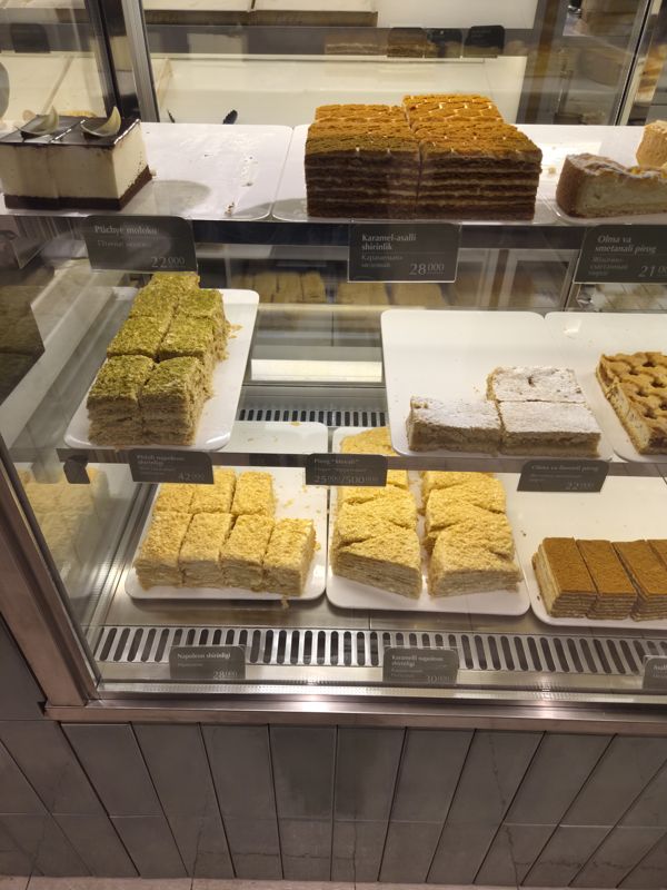 Витрина кондитерской Cakelab: порционные куски «Птичьего молока», медовика, фисташкового, обычного и карамельного наполеона, яблочных и фруктового пирогов с ценниками на узбекском и русском