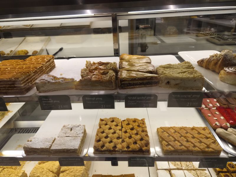 Витрина кондитерской Cakelab с пирогами: яблочно-сметанный, творожный, «Абрикосовый снежок», «Абрикос-орех», пирог с курагой, лимонник; справа круассаны и эклеры