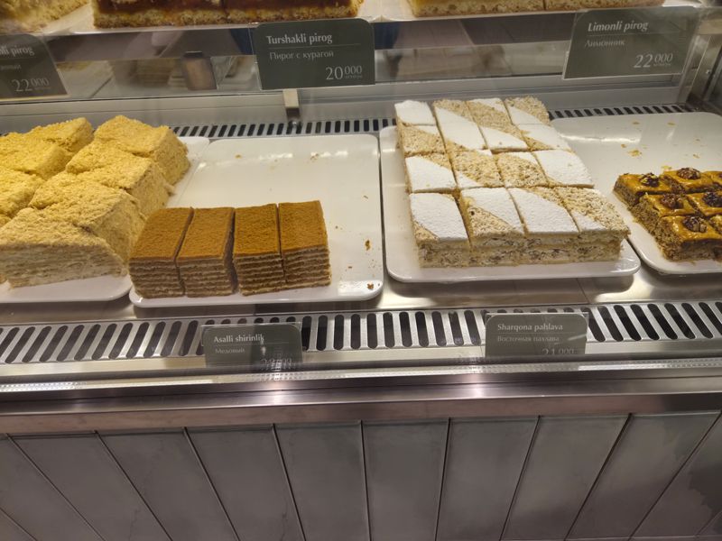 Нижняя полка витрины Cakelab: наполеон, медовик кусками, кокосовый торт с сахарной пудрой и пахлава с грецким орехом
