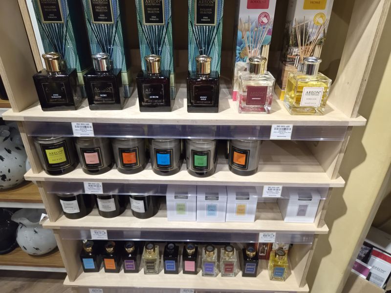Стеллаж Areon: диффузоры Premium 150 мл (Fine Tobacco, Ecru, Aurum, Sweet Gold, Aristocrat, Bubble Gum), ароматические свечи Areon Premium в стаканах, свечи Areon Moon Line в белых коробках, свечи Marcus и маленькие флаконы-диффузоры внизу