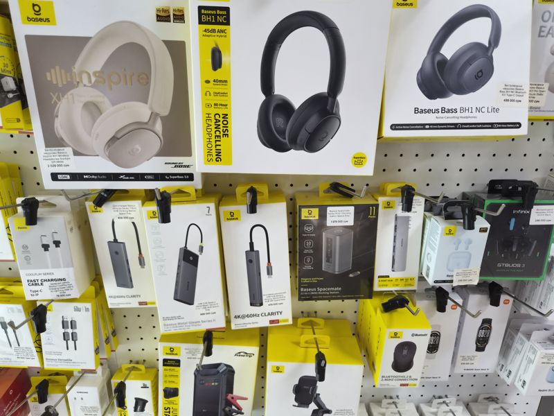 Стенд Baseus: наушники, USB-хабы и док-станции, пусковое устройство, автомобильный держатель, мышь; справа Xiaomi Smart Band 10 и Redmi Buds