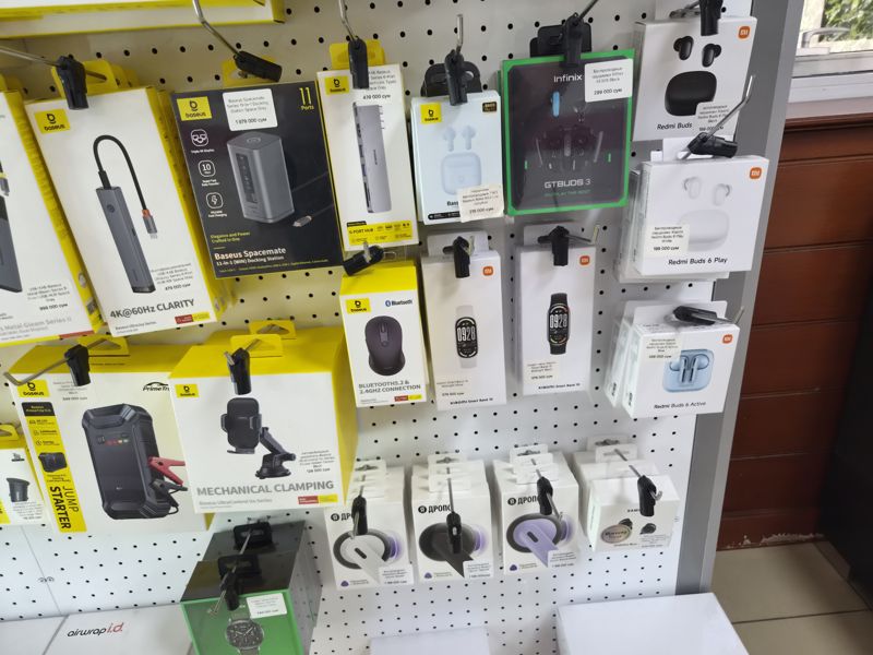 Правая часть стенда Baseus и Xiaomi: док-станции, USB-хабы, беспроводные наушники Baseus, Infinix, Xiaomi Redmi Buds, Яндекс Дропс и Samsung, умные часы Xiaomi Smart Band 10 и Infinix XWatch