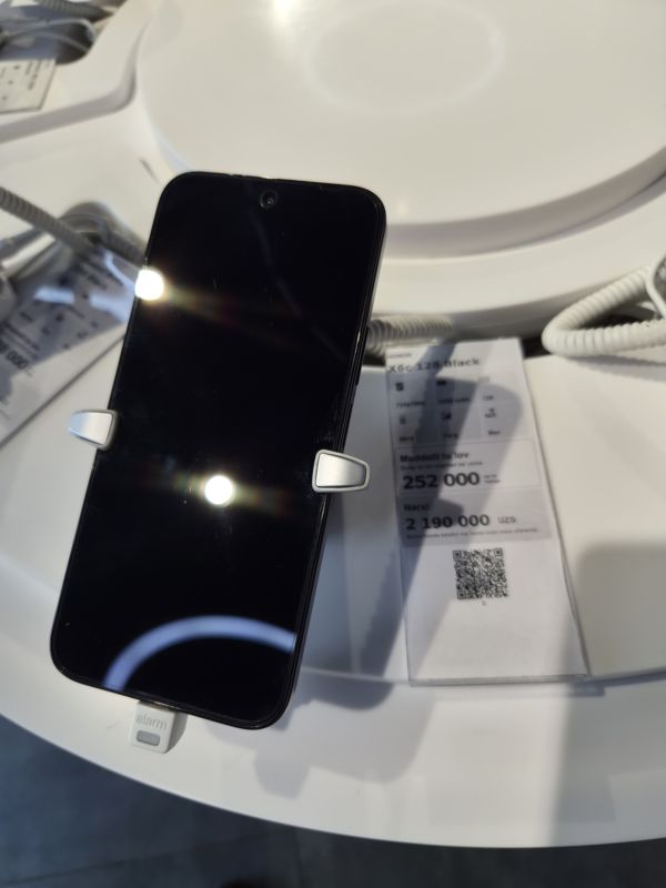Смартфон Honor X6c в держателе с сигнализацией на витрине Ucell, рядом ценник-карточка: HONOR X6c 128 Black, 2 190 000 сум