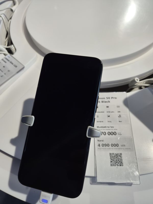 Смартфон Tecno Camon 50 Pro в держателе на витрине Ucell, рядом ценник-карточка: TECNO Camon 50 Pro 256 Black, 4 090 000 сум