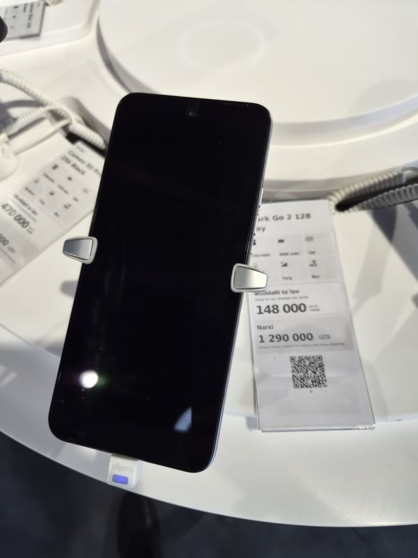 Смартфон Tecno Spark Go 2 в держателе на витрине Ucell, рядом ценник-карточка: Spark Go 2 128, 1 290 000 сум