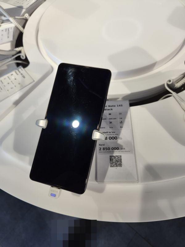Смартфон Redmi Note 14S в держателе на витрине Ucell, рядом ценник-карточка: Redmi Note 14S 128 Black, 2 850 000 сум
