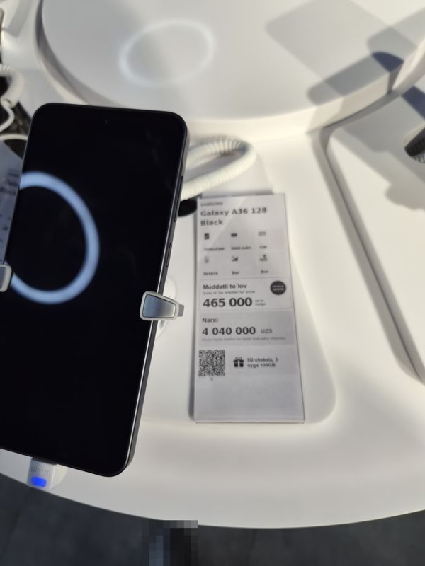 Смартфон Samsung Galaxy A36 на подставке с ценником Ucell: плашка «Maxsus aksiya» и подарок «5G cheksiz, 3 oyga 100GB»