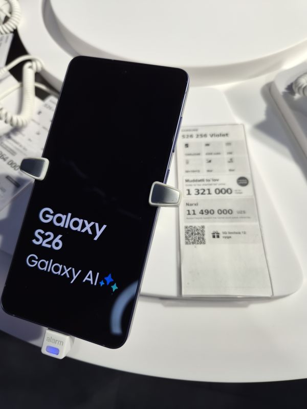 Смартфон Samsung Galaxy S26 на подставке с ценником Ucell: плашка «Maxsus aksiya» и подарок «5G limitsiz 12 oyga»