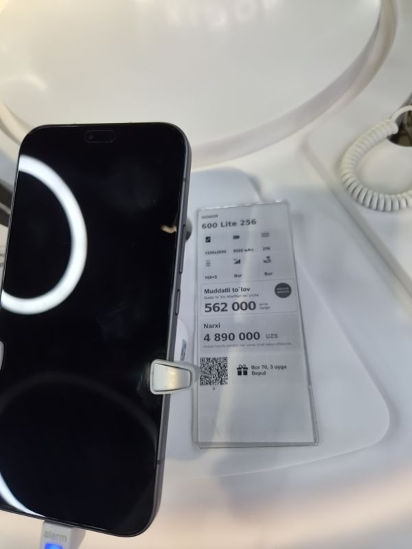 Смартфон Honor 600 Lite 256 на стенде Ucell, справа ценник-карточка с плашкой «Maxsus aksiya» и подарком к тарифу