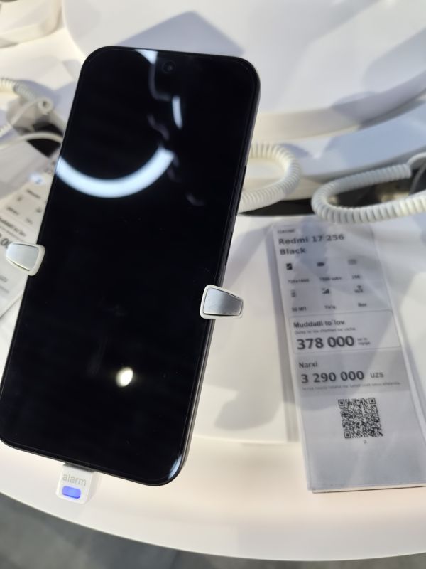 Смартфон Xiaomi Redmi 17 256 Black на стенде Ucell в держателе с сигнализацией, справа ценник-карточка