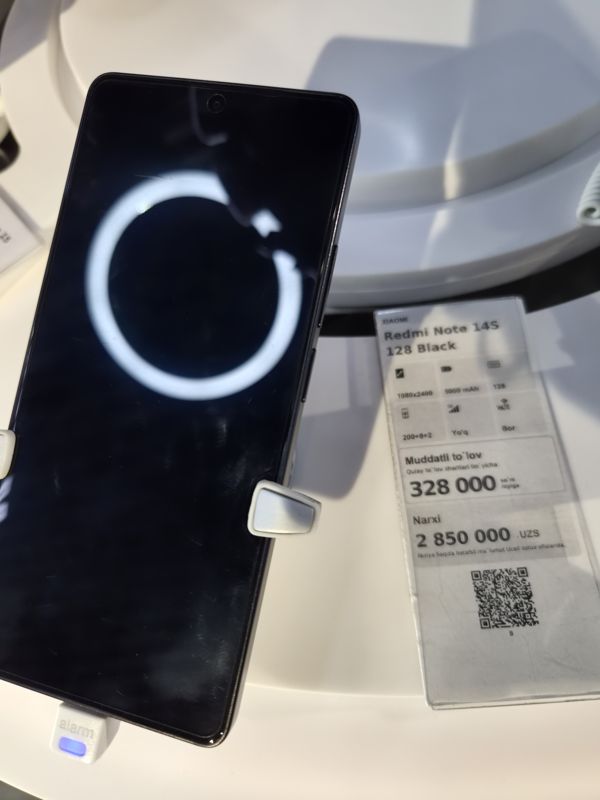 Смартфон Xiaomi Redmi Note 14S 128 Black на стенде Ucell в держателе с сигнализацией, справа ценник-карточка