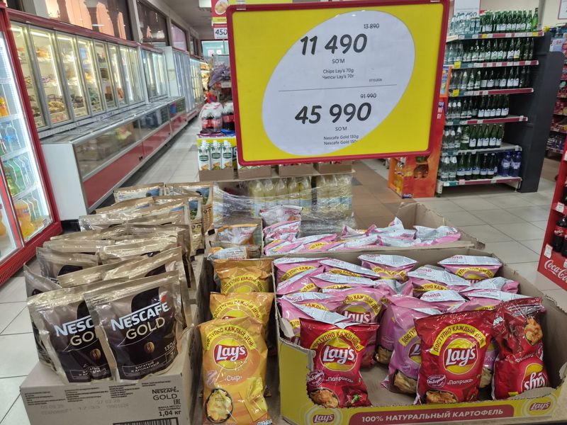 Короб с чипсами Lay's (сыр, паприка, краб) и пакеты Nescafe Gold 130 г под подвесным ценником