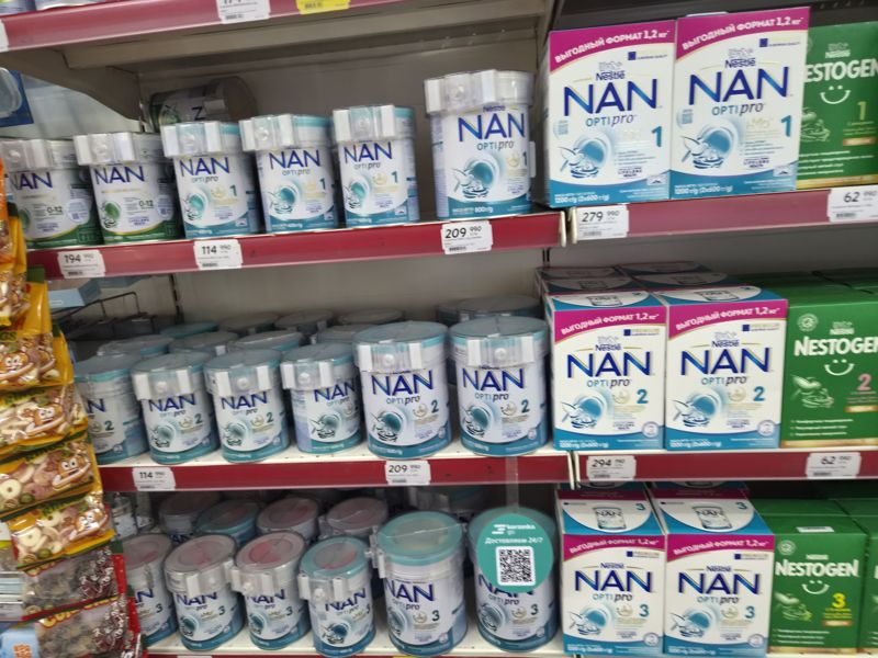 Полки с детскими смесями Nestle NAN Optipro 1, 2, 3 (банки 400 и 800 г, коробки 1,2 кг) и Nestogen 1, 2, 3 (коробки), на банках противокражные крышки; слева мармелад в пакетах