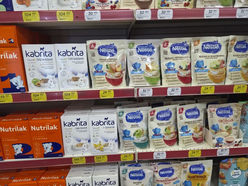 Стеллаж с детскими кашами: Kabrita (коробки), Nestle (пакеты дой-пак), на нижней полке ФрутоНяня, Агуша; жёлтые акционные ценники