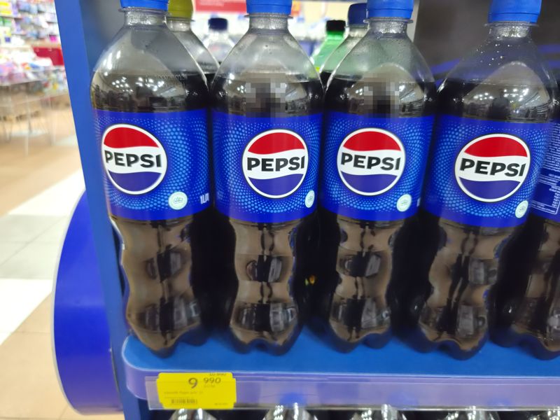 Бутылки Pepsi 1 л на синей полке-подставке с жёлтым акционным ценником Pepsi 1 л
