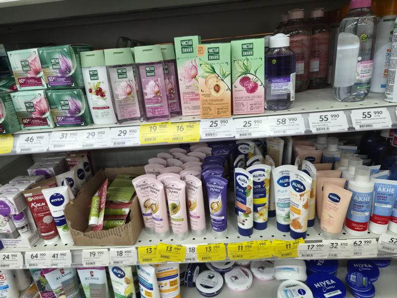 Полка косметики «Чистая линия», Garnier, BioCosmetolog, Nivea и кремов для рук (Калина, Бархатные ручки, Aura, BQ, Belita); полочные ценники с штрихкодами, часть жёлтых «Hafta super narxlari»