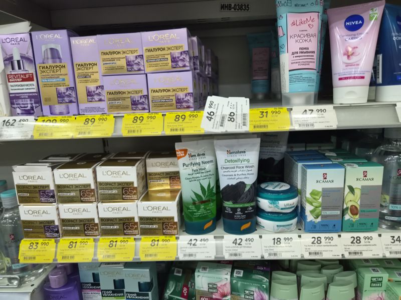 Полки с кремами для лица L'Oreal (Гиалурон Эксперт, Возраст Эксперт), Himalaya, «Я Самая», «Чистая линия»; на полочных планках белые и жёлтые ценники «Hafta super narxlari»