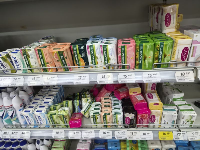 Полки с мылом Palmolive, Protex, Camay и Dove, ниже дезодоранты Rexona; под полками белые ценники и один жёлтый «Hafta super narxlari»