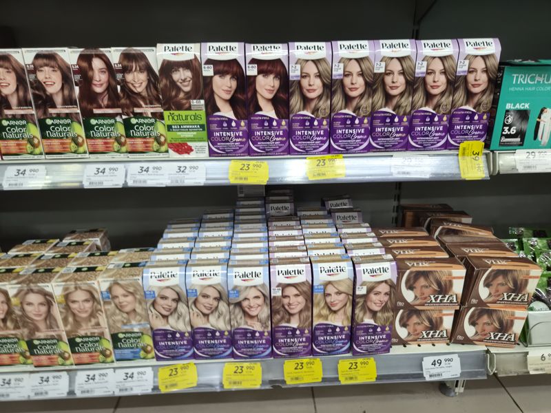 Краски для волос Palette (Intensive Color Creme, Naturals), Garnier Color Naturals и иранская хна, справа хна Trichup; на полках белые и жёлтые «Hafta super narxlari» ценники, часть смазана
