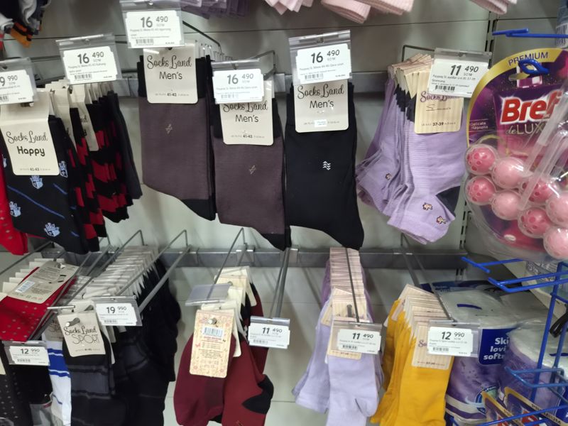 Мужские и женские носки Socks Land на крючках, ценники на держателях; справа туалетный блок Bref