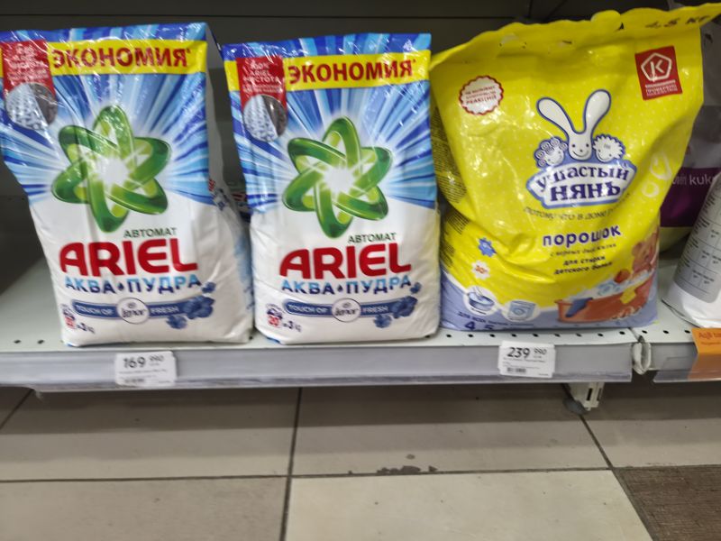Полка со стиральными порошками Ariel Аква-Пудра Touch of Lenor Fresh 3 кг и «Ушастый нянь» 4,5 кг; ценники смазаны