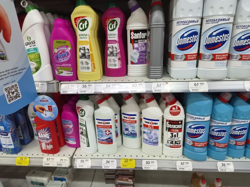 Полки с чистящими средствами для туалета, ванной, плит и ковров: Cif, Vanish, Sanfor, Domestos, Grass, Chistin, Cillit Bang; ценники на кромках полок