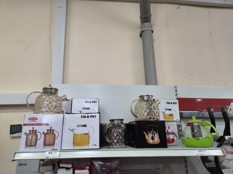 Верхняя полка с стеклянными заварочными чайниками SOF Glass и Tea & Pot; на краю полки два ценника