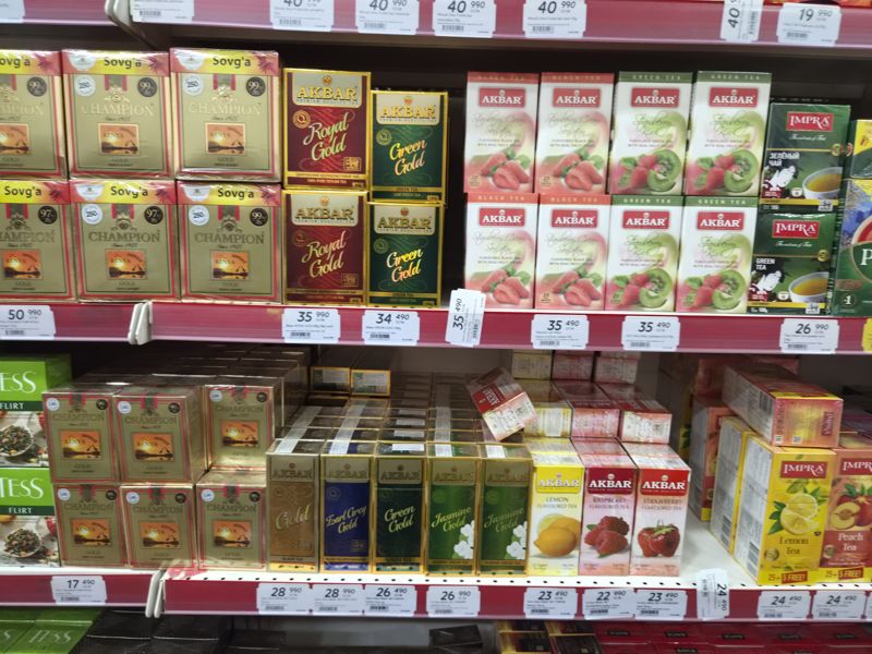 Чай Champion Gold Kenya Sunset, Akbar (Royal Gold, Green Gold, Strawberry Cream, Strawberry Kiwi, S&T), Impra и Mevali Frutta bar на полках; ценники с ценами