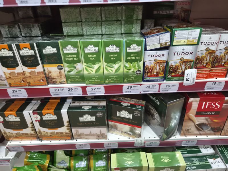 Полки с чаем Ahmad Tea (Ceylon, Earl Grey, English Tea No.1, Jasmine, Green, Mint, English Breakfast), Tudor, Tess Sunrise; ряды ценников и два ценника повёрнуты вертикально