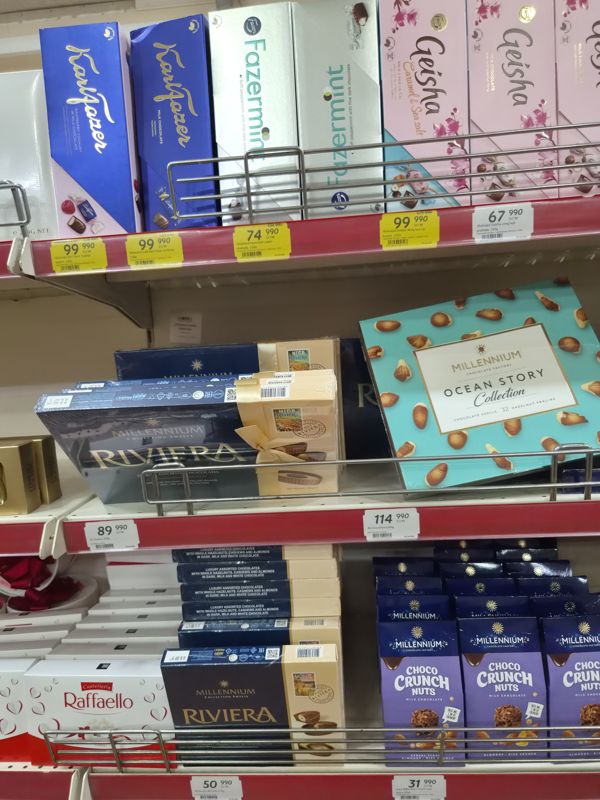 Витрина шоколадных конфет: Karl Fazer, Fazermint, Geisha, Millennium Riviera, Ocean Story, Choco Crunch Nuts, Raffaello; жёлтые ценники с зачёркнутой старой ценой