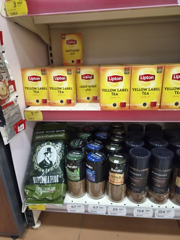 Полки с чаем Lipton Yellow Label и растворимым кофе Jardin и Davidoff; слева на крючке пакетики какао и кофе в зёрнах Diplomatico; жёлтые ценники «Hafta super narxlari»