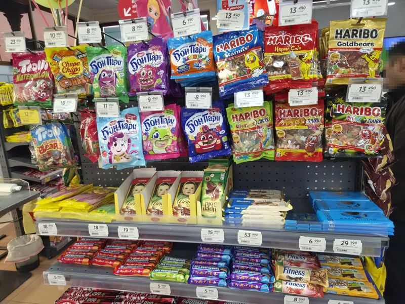 Стойка с мармеладом Haribo, Бон Пари, Trolli, Chupa Chups и Fruittella на крючках; ниже шоколад Алёнка, Alpen Gold, Ulker, Рахат и батончики Strobar, Fitness