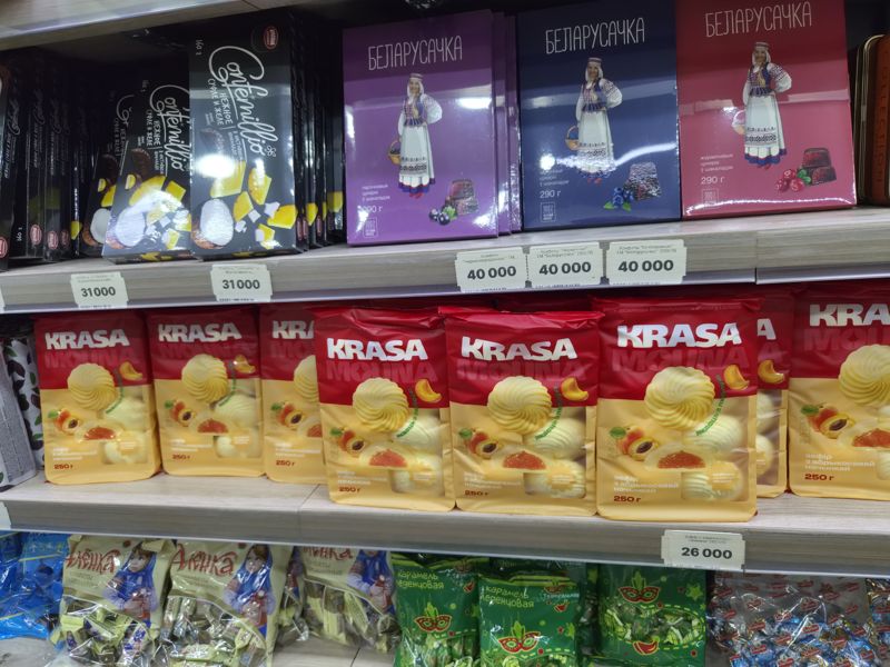 Полки магазина белорусских продуктов: конфеты Confemillio, шоколадные конфеты «Белорусочка» в коробках, зефир Krasa с абрикосовой начинкой, конфеты «Аленка» и карамель «Театральная» без ценников