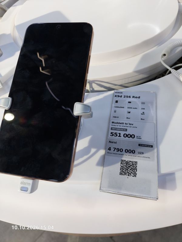 Смартфон Honor X9d в держателе с сигнализацией на витрине Ucell, рядом ценник-карточка: HONOR X9d 256 Red, 4 790 000 сум, перечёркнутая прежняя цена 5 190 000