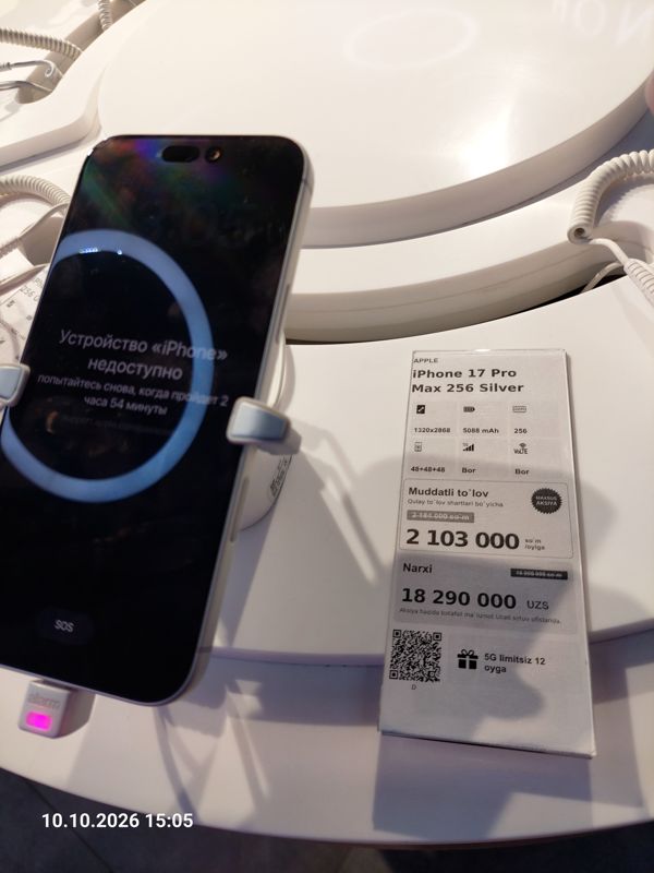 Смартфон iPhone 17 Pro Max в держателе с сигнализацией на витрине Ucell, рядом ценник-карточка: APPLE iPhone 17 Pro Max 256 Silver, плашка «Maxsus aksiya», 18 290 000 сум, перечёркнутая прежняя цена 18 990 000