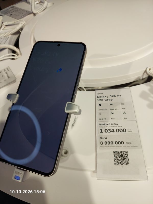 Демонстрационный смартфон Galaxy S26 FE на подставке с ценником-карточкой Ucell «Galaxy S26 FE 128 Gray», 8 990 000 сум