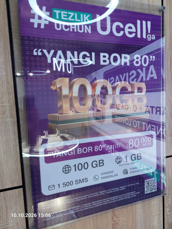 Рекламный плакат Ucell в стеклянной раме на стене: «#Tezlik uchun Ucell'ga», тариф «Yangi BOR 80» — 100 GB, 80 000 сум