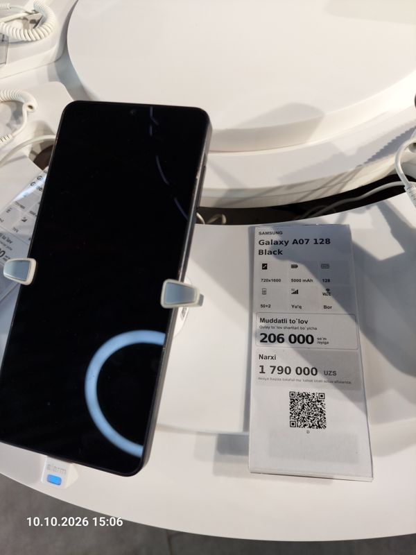 Смартфон Samsung Galaxy A07 в держателе с сигнализацией на витрине Ucell, рядом ценник-карточка: SAMSUNG Galaxy A07 128 Black, 1 790 000 сум