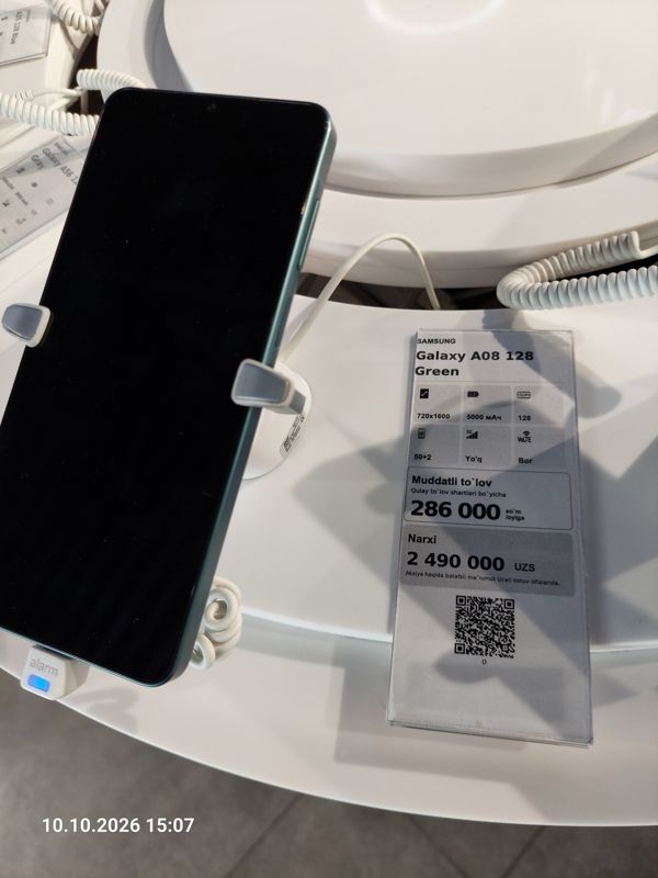 Смартфон Samsung Galaxy A08 в держателе с сигнализацией на витрине Ucell, рядом ценник-карточка: SAMSUNG Galaxy A08 128 Green, 2 490 000 сум