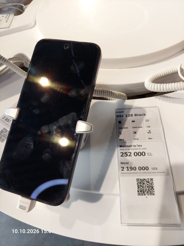 Смартфон Honor X6c в держателе с сигнализацией на витрине Ucell, рядом ценник-карточка: HONOR X6c 128 Black, 2 190 000 сум