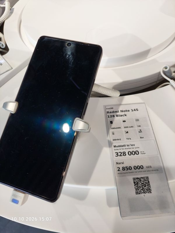 Смартфон Xiaomi Redmi Note 14S в держателе с сигнализацией на витрине Ucell, рядом ценник-карточка: XIAOMI Redmi Note 14S 128 Black, 2 850 000 сум