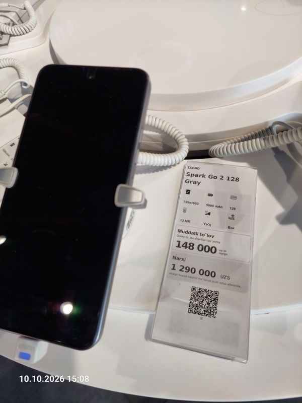 Смартфон Tecno Spark Go 2 в держателе с сигнализацией на витрине Ucell, рядом ценник-карточка: TECNO Spark Go 2 128 Gray, 1 290 000 сум