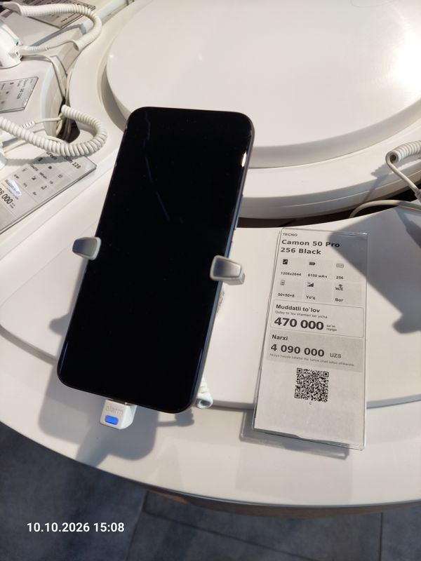 Смартфон Tecno Camon 50 Pro в держателе с сигнализацией на витрине Ucell, рядом ценник-карточка: TECNO Camon 50 Pro 256 Black, 4 090 000 сум