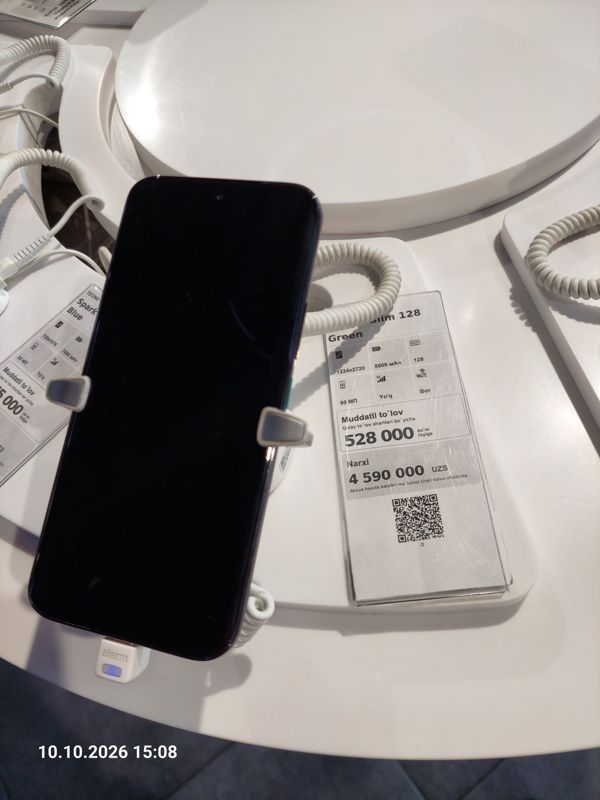 Смартфон Tecno Camon Slim в держателе с сигнализацией на витрине Ucell, рядом ценник-карточка: Camon Slim 128 Green, 4 590 000 сум
