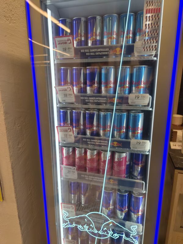 Холодильная витрина Red Bull со стеклянной дверью: банки Red Bull, Sugar Free и Peach Edition, ценники с красной плашкой «Narxiga javob!» и белые