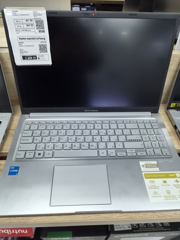 Ноутбук ASUS VivoBook 15 на витрине, слева на крышке два ценника один под другим